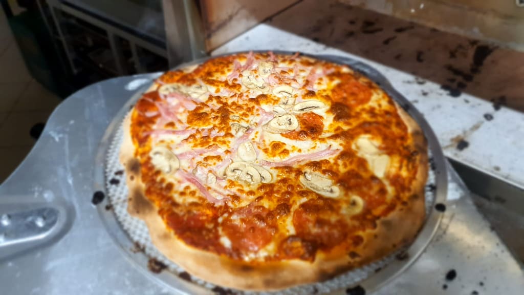 Pizza prosto z pieca na metalowej łopacie